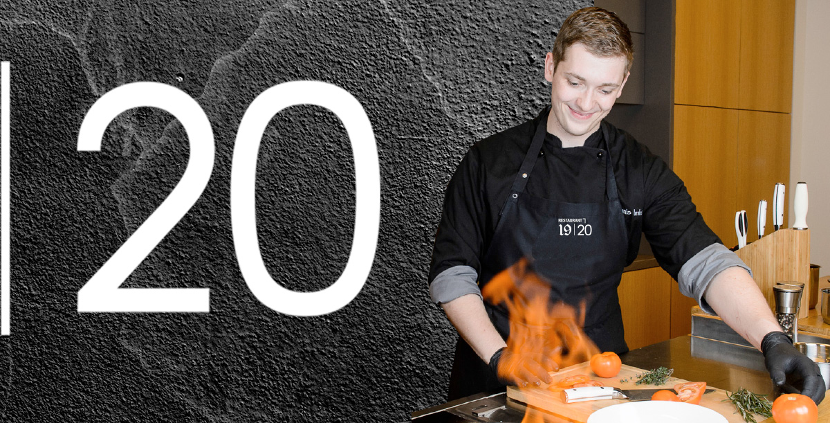 Koch mit schwarzer Kochjacke und Schürze steht an der Live-Cooking Station im Restaurant 19 | 20 in Karlstadt