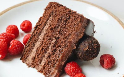 Ein Stück Schokoladenmousse-Torte mit roten Früchten liegt auf einem Teller im Restaurant Karlstadt